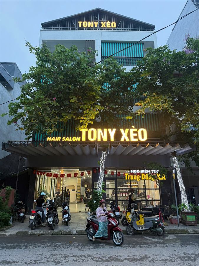 Mặt tiền salon Tony Xèo buổi tối, biển hiệu phát sáng
